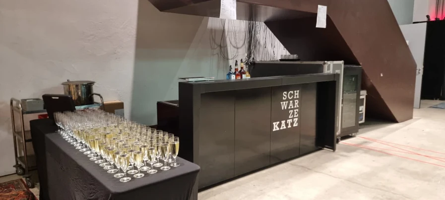 Mobile Schwarze-Katz-Bar mit Sektgläsern bei einem Empfang